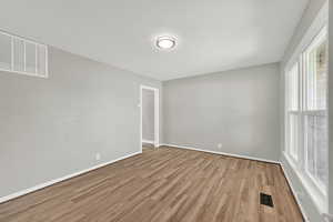 Spare room featuring light wood-type flooring and baseboards