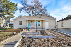 View of front facade featuring a vegetable garden, a porch, and roof with shingles
