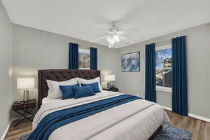 Bedroom featuring light wood-style floors, ceiling fan, and multiple windows