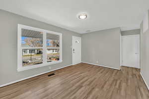 Spare room featuring light wood-style flooring and baseboards