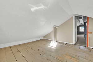 Bonus room featuring vaulted ceiling, a textured ceiling, and wood-type flooring
