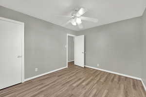 Unfurnished bedroom with wood finished floors and a ceiling fan