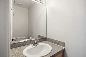 Half bathroom with vanity and toilet