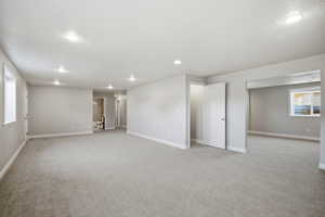 Unfurnished room with light colored carpet and recessed lighting