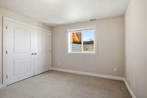 Unfurnished bedroom featuring carpet and a closet