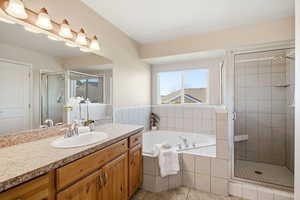 Full bathroom featuring a bath, a shower stall, vanity, and light tile patterned floors