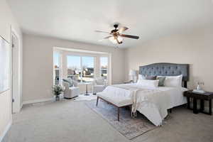 Carpeted bedroom featuring baseboards and a ceiling fan