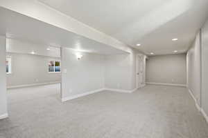 Below grade area with light carpet, recessed lighting, and a textured ceiling
