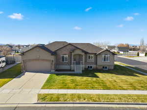 View of front of house with driveway, a front yard, and an attached garage