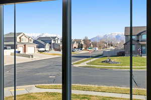View of asphalt street with sidewalks, a mountain view, a residential view, and curbs