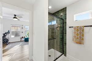 Bathroom featuring plenty of natural light, a shower stall, and ceiling fan