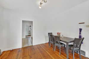 Dining space with wood-type flooring and baseboards