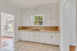 Kitchen with light countertops, plenty of natural light, and white cabinetry