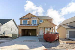 Unfinished property featuring concrete driveway, an attached garage, and covered porch