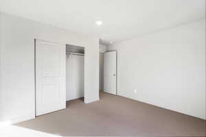 Unfurnished bedroom with carpet flooring and a closet