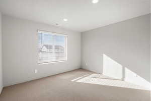 Empty room with carpet and recessed lighting