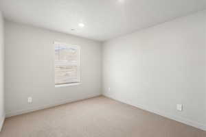 Unfurnished room with light carpet, a textured ceiling, and recessed lighting