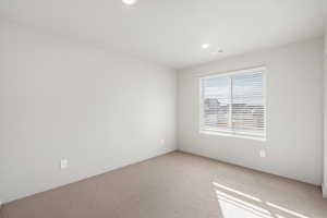 Carpeted empty room featuring baseboards and recessed lighting