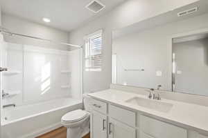 Bathroom featuring bathing tub / shower combination, vanity, and dark wood-type flooring