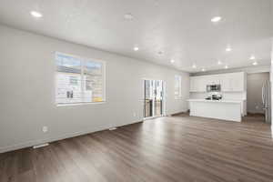 Unfurnished living room featuring recessed lighting, dark wood-style flooring, and a textured ceiling