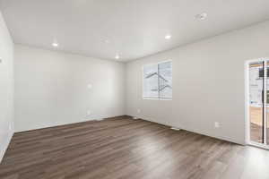 Empty room with light wood-style floors and recessed lighting