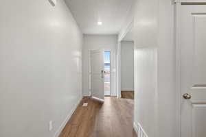 Hallway featuring wood finished floors and a textured ceiling