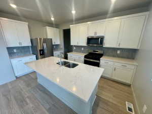 Kitchen featuring white cabinetry, appliances with stainless steel finishes, tasteful backsplash, and recessed lighting