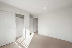 Unfurnished bedroom with carpet flooring, a closet, and recessed lighting