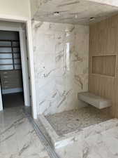 Bathroom with marble tiled flooring and a marble finish shower