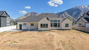 Back of house featuring a patio area, a fenced backyard, a mountain view, and stucco siding