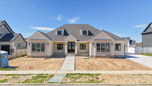 View of front facade featuring french doors and roof with shingles