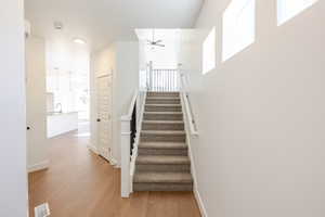 Stairway featuring wood finished floors and a ceiling fan