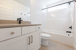 Bathroom with vanity, shower / bathtub combination, and light tile patterned floors