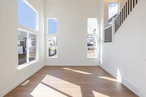 Unfurnished room with dark wood-type flooring and a high ceiling