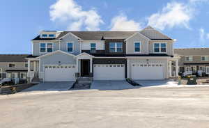 View of front of house featuring board and batten siding, a garage, and driveway