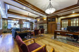 Office area featuring a stone fireplace, crown molding, a baseboard heating unit, and recessed lighting