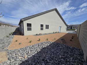 Rear view of property with a fenced backyard and stucco siding