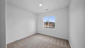 Empty room with baseboards and light colored carpet