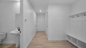 Mudroom with light wood finished floors and recessed lighting