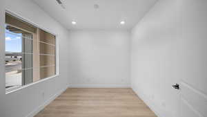 Empty room featuring light wood finished floors and recessed lighting