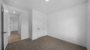 Unfurnished bedroom featuring dark colored carpet and recessed lighting