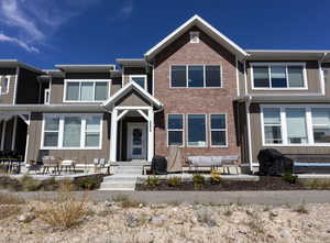 View of front of property featuring outdoor lounge area, board and batten siding, and brick siding