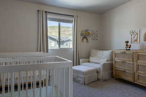 Bedroom with carpet and a crib