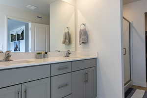 Bathroom featuring double vanity and a shower stall