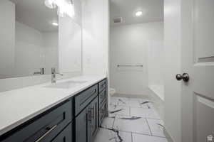 Full bathroom featuring light marble finish flooring, vanity, and  shower combination
