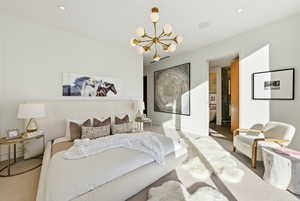 Bedroom featuring a chandelier, connected bathroom, and recessed lighting
