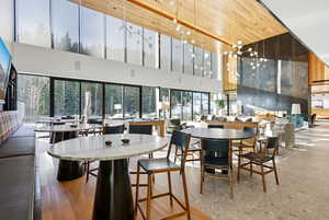 Dining space with wood ceiling, a towering ceiling, and a chandelier