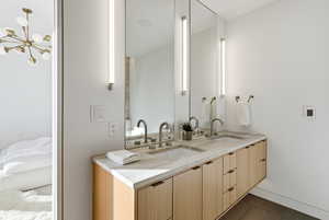 Bathroom featuring double vanity and dark tile patterned flooring