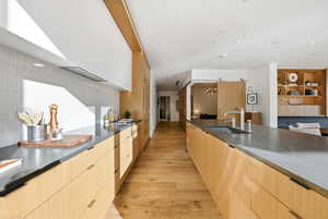 Kitchen with modern cabinets, a chandelier, light wood-style flooring, light brown cabinets, and recessed lighting