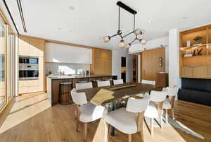 Dining area with light wood-type flooring, a chandelier, and recessed lighting